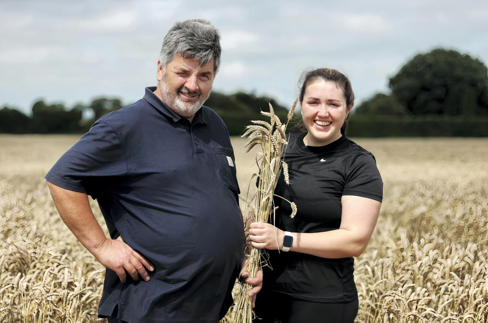 Tom Tierney and Erin Tierney holding a stalk of wheat